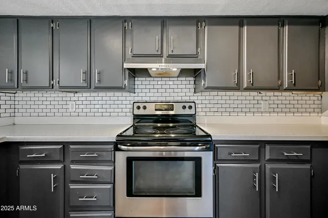 a kitchen with granite countertop white cabinets and stainless steel appliances