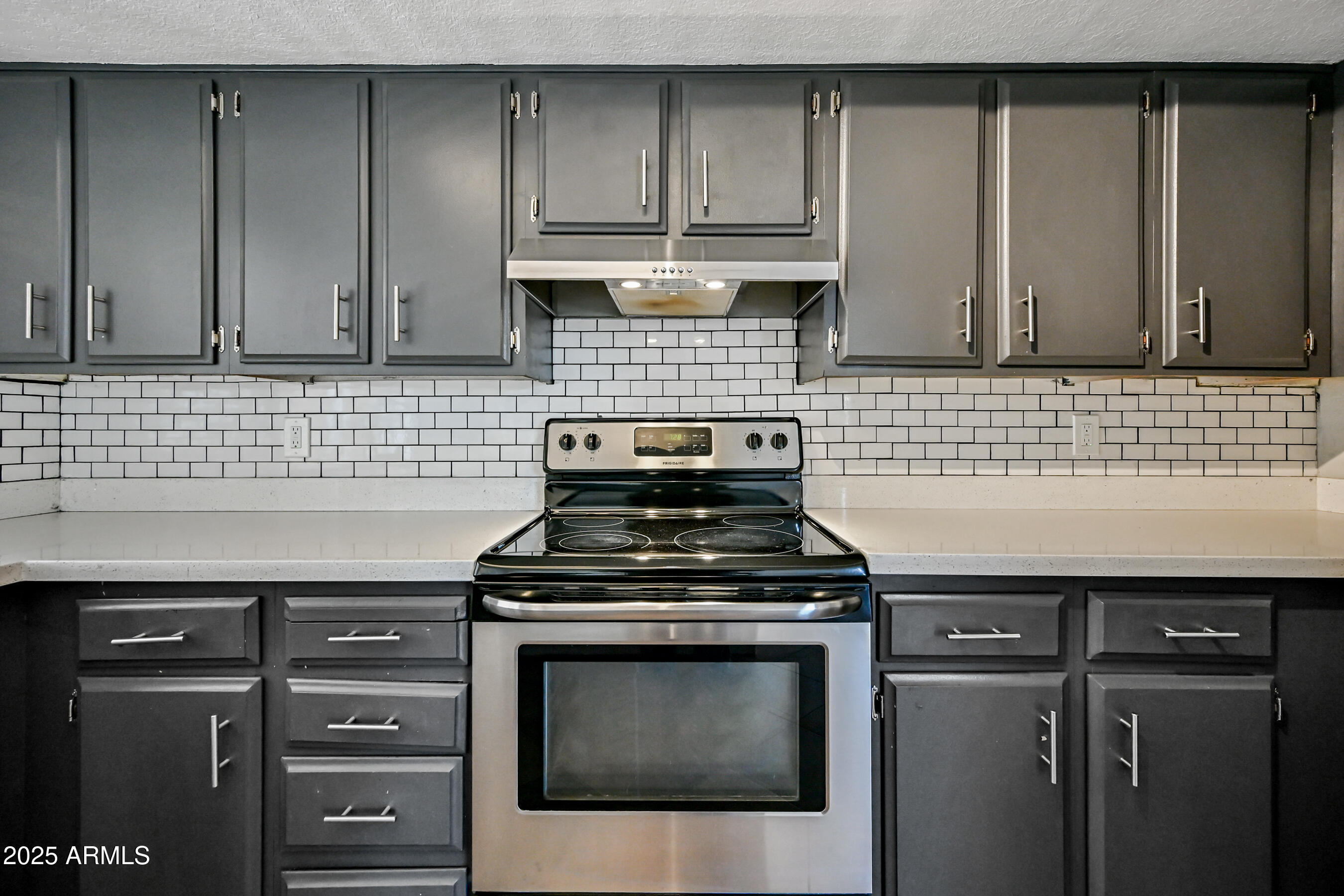 5558 West Cortez Street Glendale, AZ 85304 - Photo 11 of 34 a kitchen with granite countertop white cabinets and stainless steel appliances