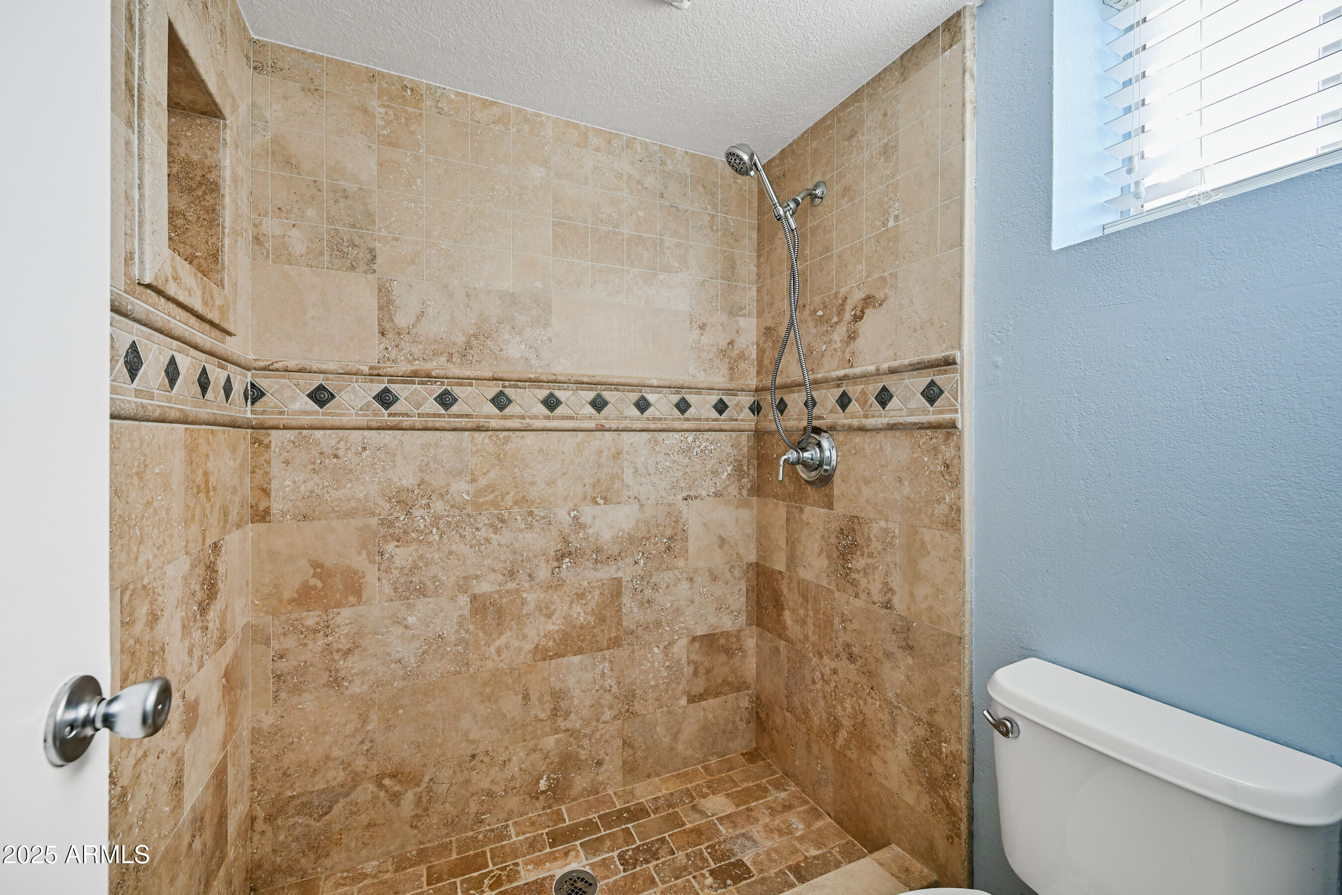 5558 West Cortez Street Glendale, AZ 85304 - Photo 26 of 34 a bathroom with a shower a toilet and a window