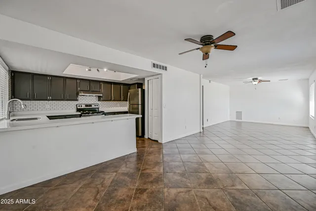 a kitchen with stainless steel appliances a refrigerator sink and microwave