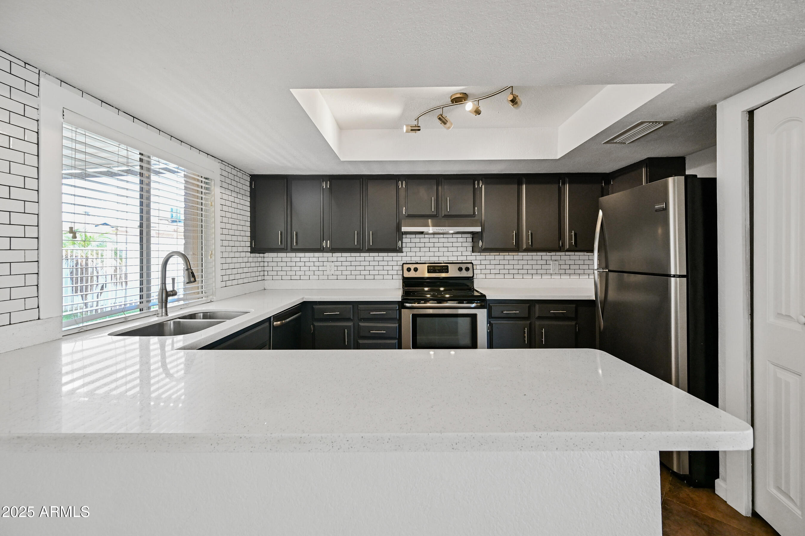 5558 West Cortez Street Glendale, AZ 85304 - Photo 9 of 34 a kitchen with stainless steel appliances granite countertop a sink refrigerator and cabinets