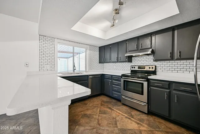 a kitchen with granite countertop a stove and a sink