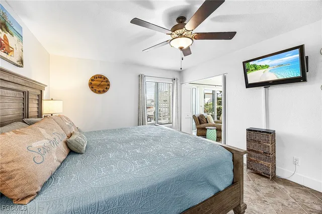 a bedroom with a large bed a flat tv screen and a dresser