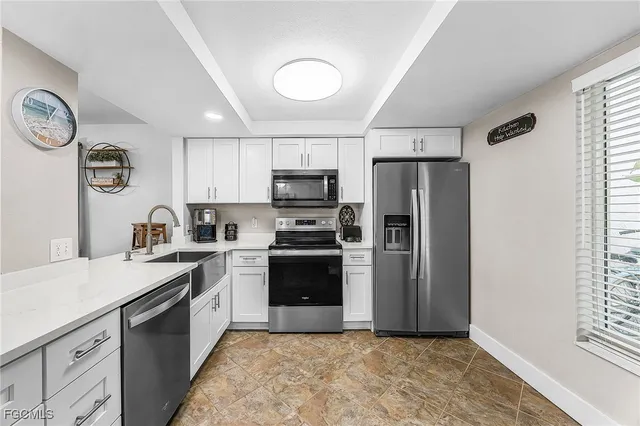 a kitchen with granite countertop a refrigerator stove and sink