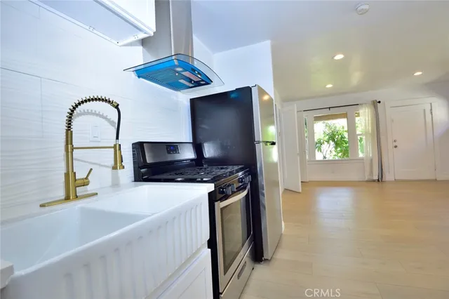 a kitchen with stainless steel appliances granite countertop a sink and a stove top oven