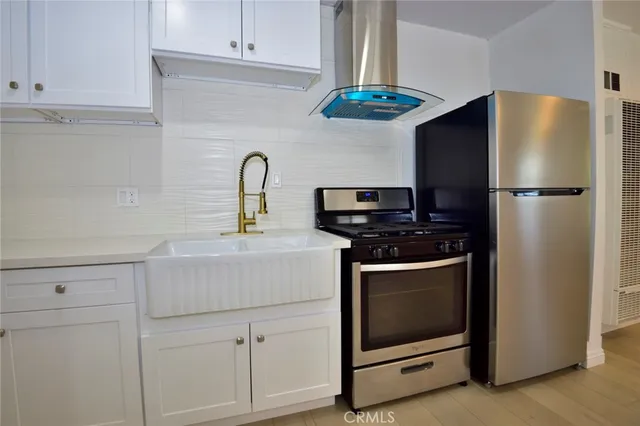a kitchen with stainless steel appliances white cabinets and a refrigerator