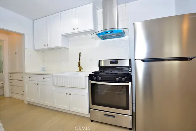 a kitchen with stainless steel appliances white cabinets and a refrigerator