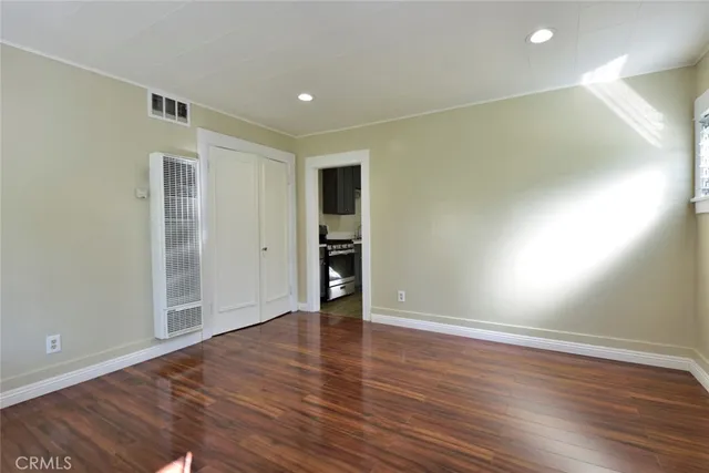 an empty room with wooden floor and closet