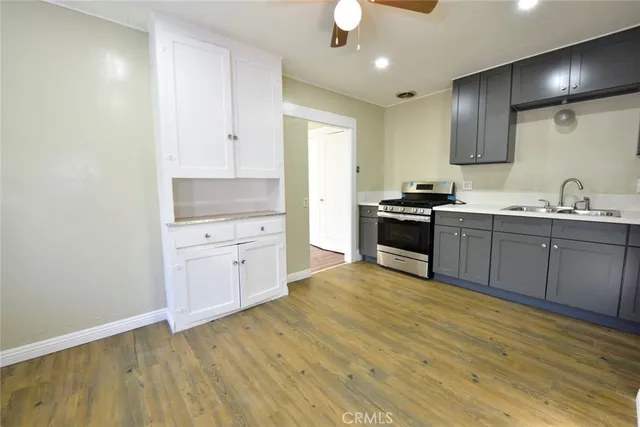 a kitchen with granite countertop a sink cabinets and stainless steel appliances