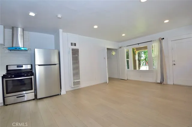 a view of a kitchen with a sink refrigerator and window