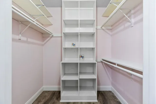 a view of walk in closet with empty racks
