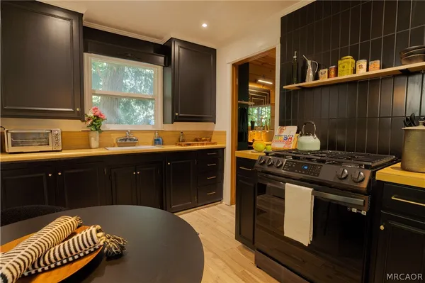 a kitchen with stainless steel appliances a sink stove and cabinets