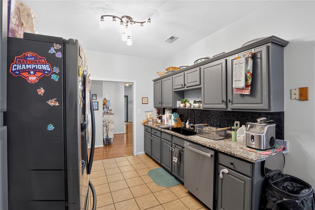 144 Elliott Circle Anderson, SC 29621 - Photo 10 of 30 A well-appointed kitchen features ample gray cabinetry and practical tile flooring, ideal for everyday living.