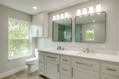 a bathroom with a toilet a sink and a large mirror