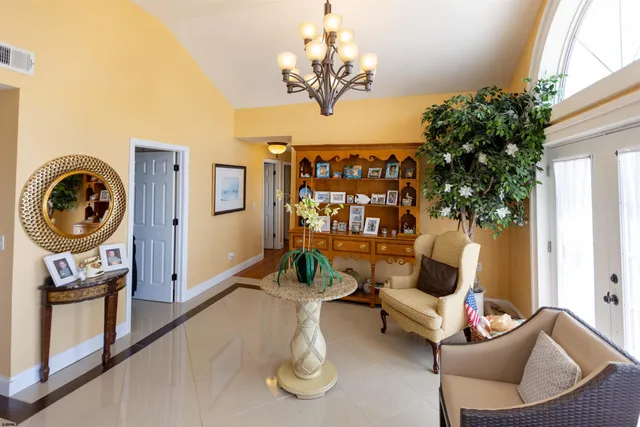 a living room with furniture floor to ceiling window and wooden floor