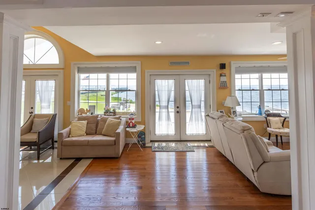 a view of a hallway with wooden floor and a bathroom