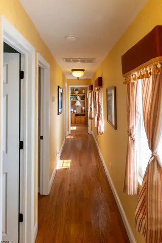 a bedroom with a bed large window with wooden floor