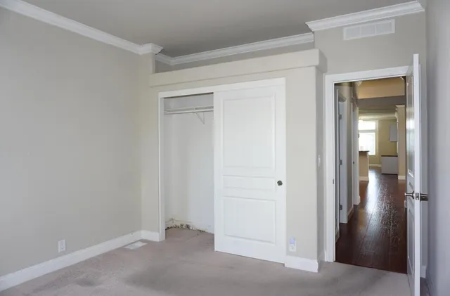 an empty room that has a wooden cupboard