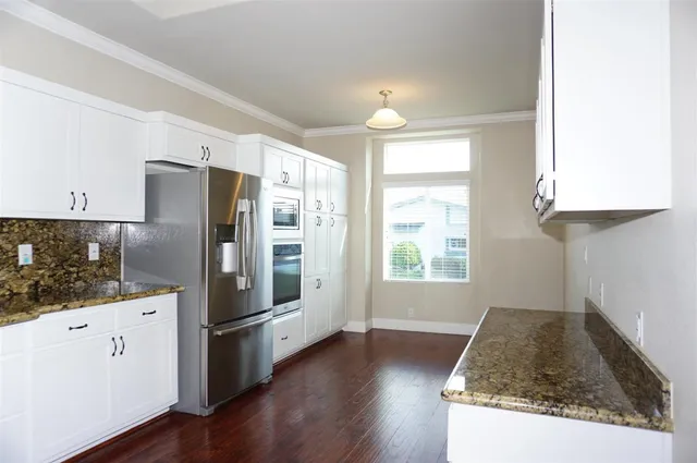 a kitchen with stainless steel appliances granite countertop a refrigerator and a stove