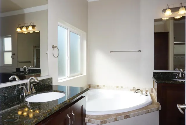 a bathroom with a granite countertop sink and a mirror