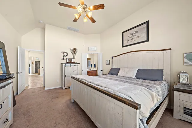 a spacious bedroom with a bed and a chandelier