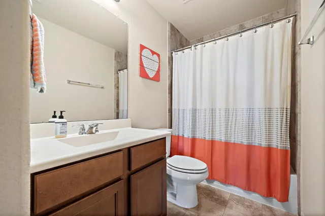a bathroom with a sink a toilet and shower curtain