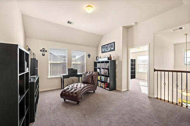 a living room with furniture and a refrigerator