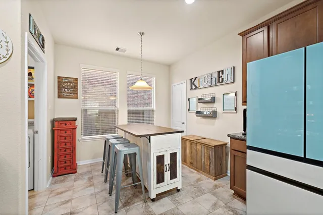 a kitchen that has a fridge and a stove top oven
