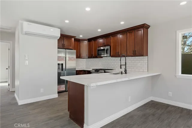 a kitchen with stainless steel appliances granite countertop wooden cabinets a stove top oven a sink and dishwasher