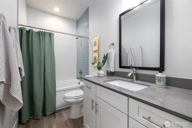a bathroom with a granite countertop sink toilet and shower