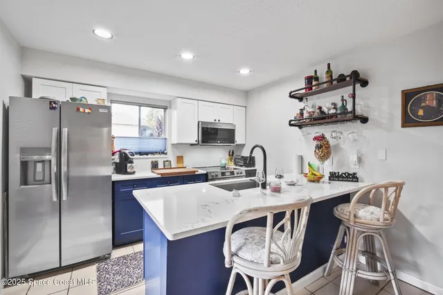 a kitchen with stainless steel appliances granite countertop a dining table and chairs