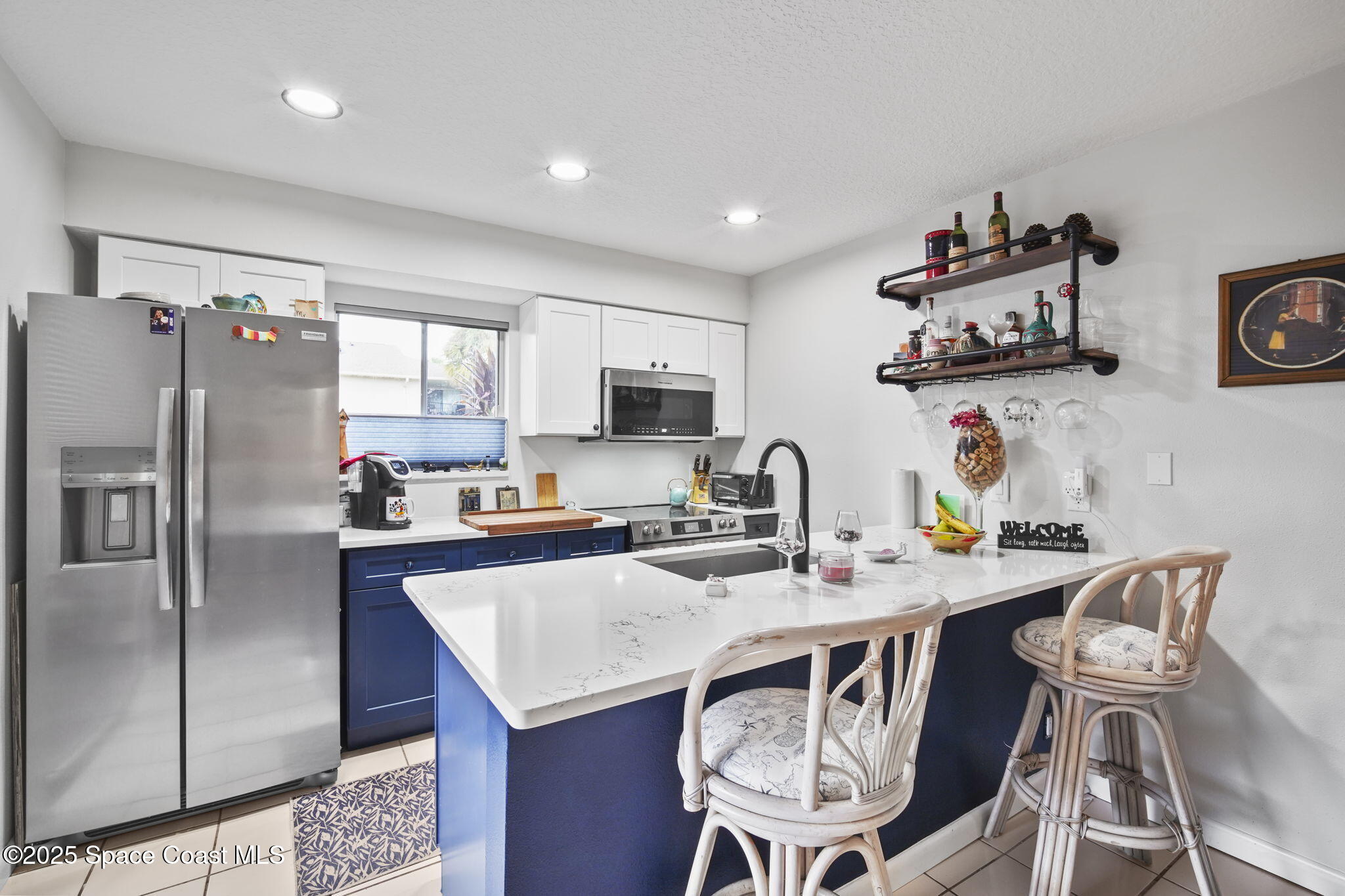 4148 Prime Avenue, Unit 1504 Rockledge, FL 32955 - Photo 13 of 30 a kitchen with stainless steel appliances granite countertop a dining table and chairs