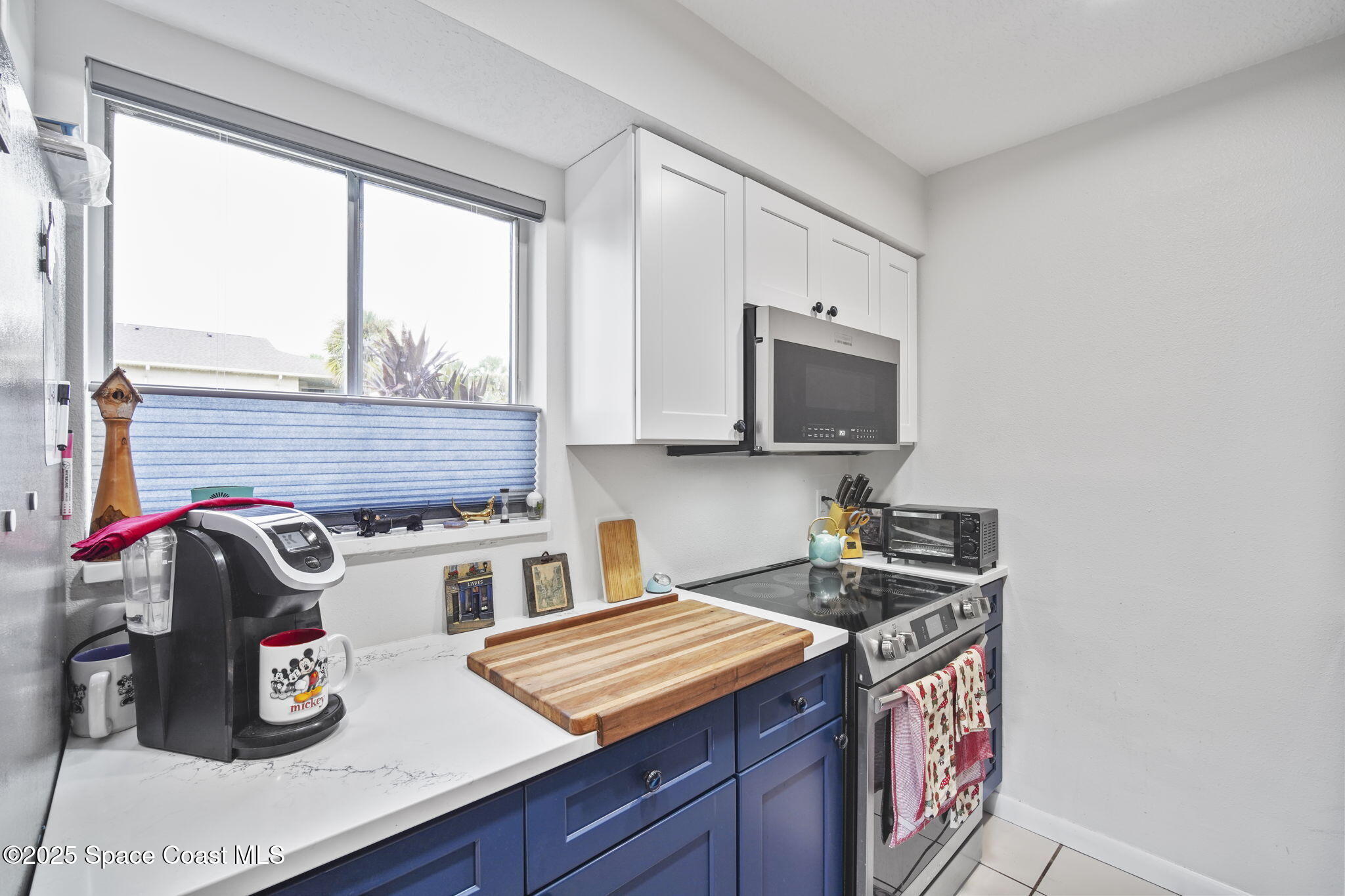 4148 Prime Avenue, Unit 1504 Rockledge, FL 32955 - Photo 14 of 30 a kitchen with stainless steel appliances a sink a stove and a microwave