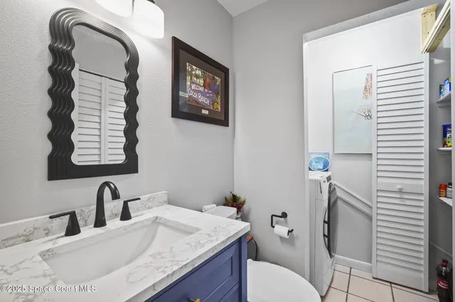 a bathroom with a granite countertop toilet sink and mirror