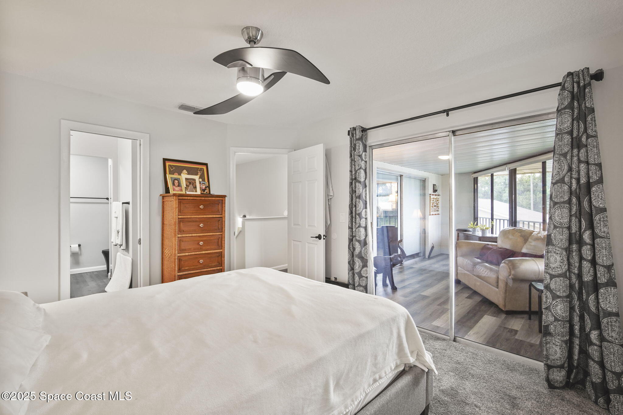 4148 Prime Avenue, Unit 1504 Rockledge, FL 32955 - Photo 24 of 30 a bedroom with a large bed and a chandelier