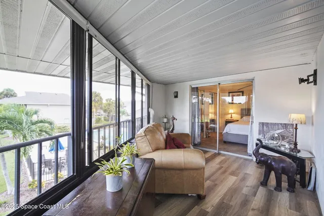 a living room with furniture and floor to ceiling windows