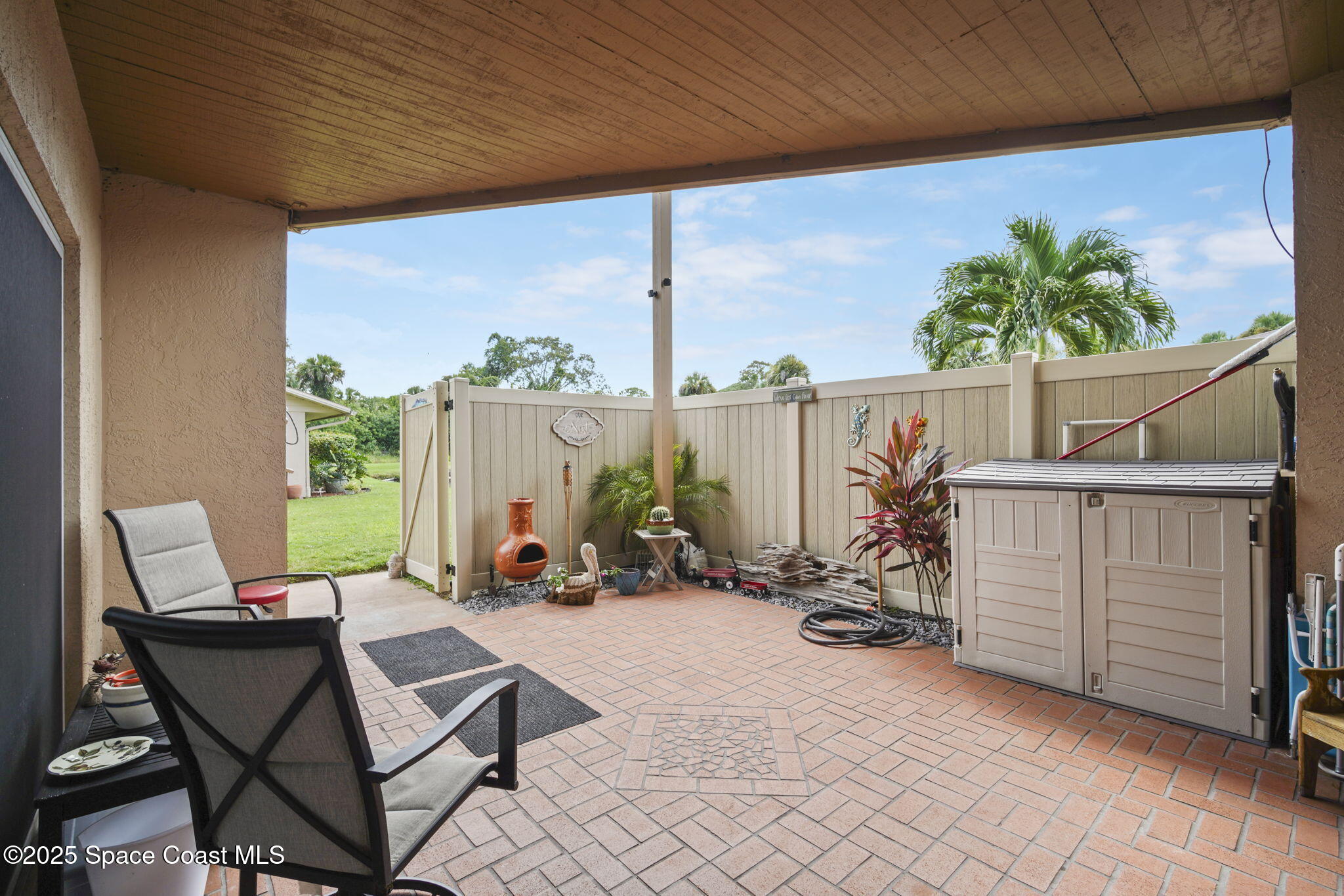4148 Prime Avenue, Unit 1504 Rockledge, FL 32955 - Photo 5 of 30 a view of a patio with a table and chairs next to a yard