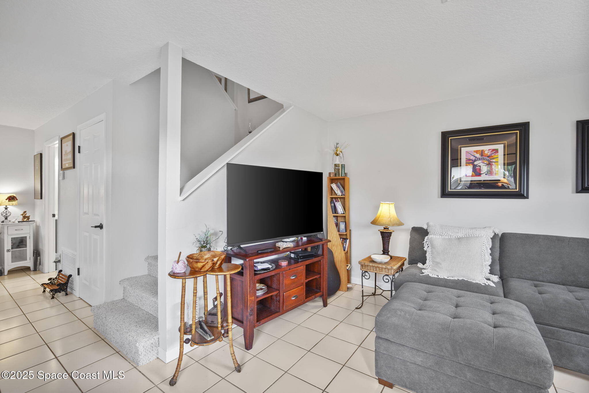 4148 Prime Avenue, Unit 1504 Rockledge, FL 32955 - Photo 8 of 30 a living room with furniture and a flat screen tv