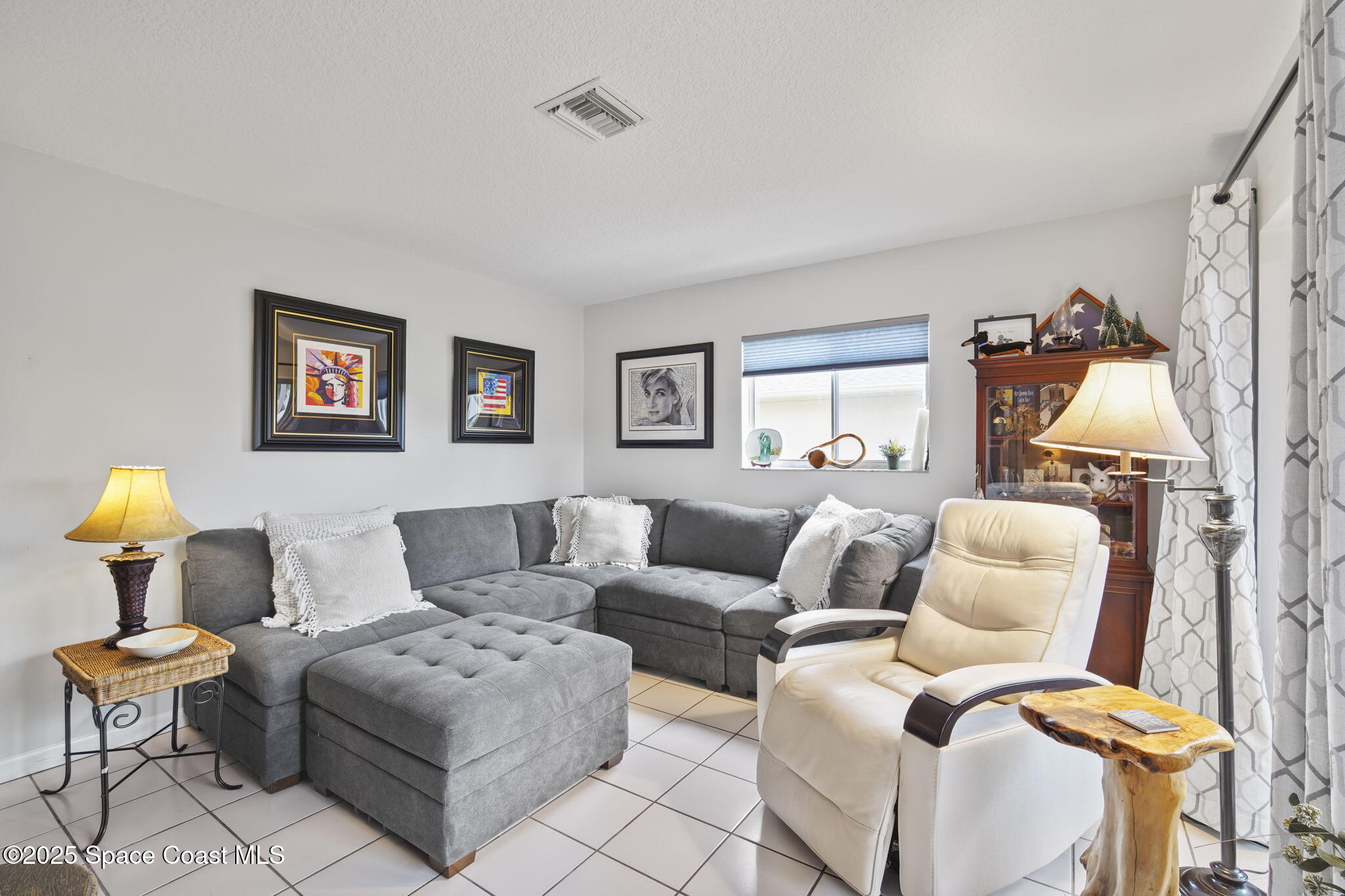 4148 Prime Avenue, Unit 1504 Rockledge, FL 32955 - Photo 9 of 30 a living room with furniture and a lamp