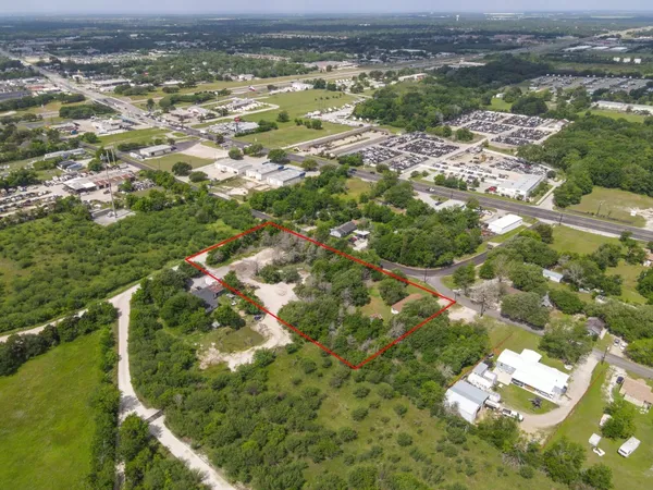 an aerial view of residential houses with outdoor space and trees