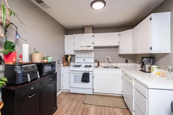 a kitchen with a sink stove and white cabinets