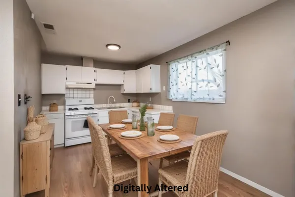 a open dining room with stainless steel appliances a dining table and chairs