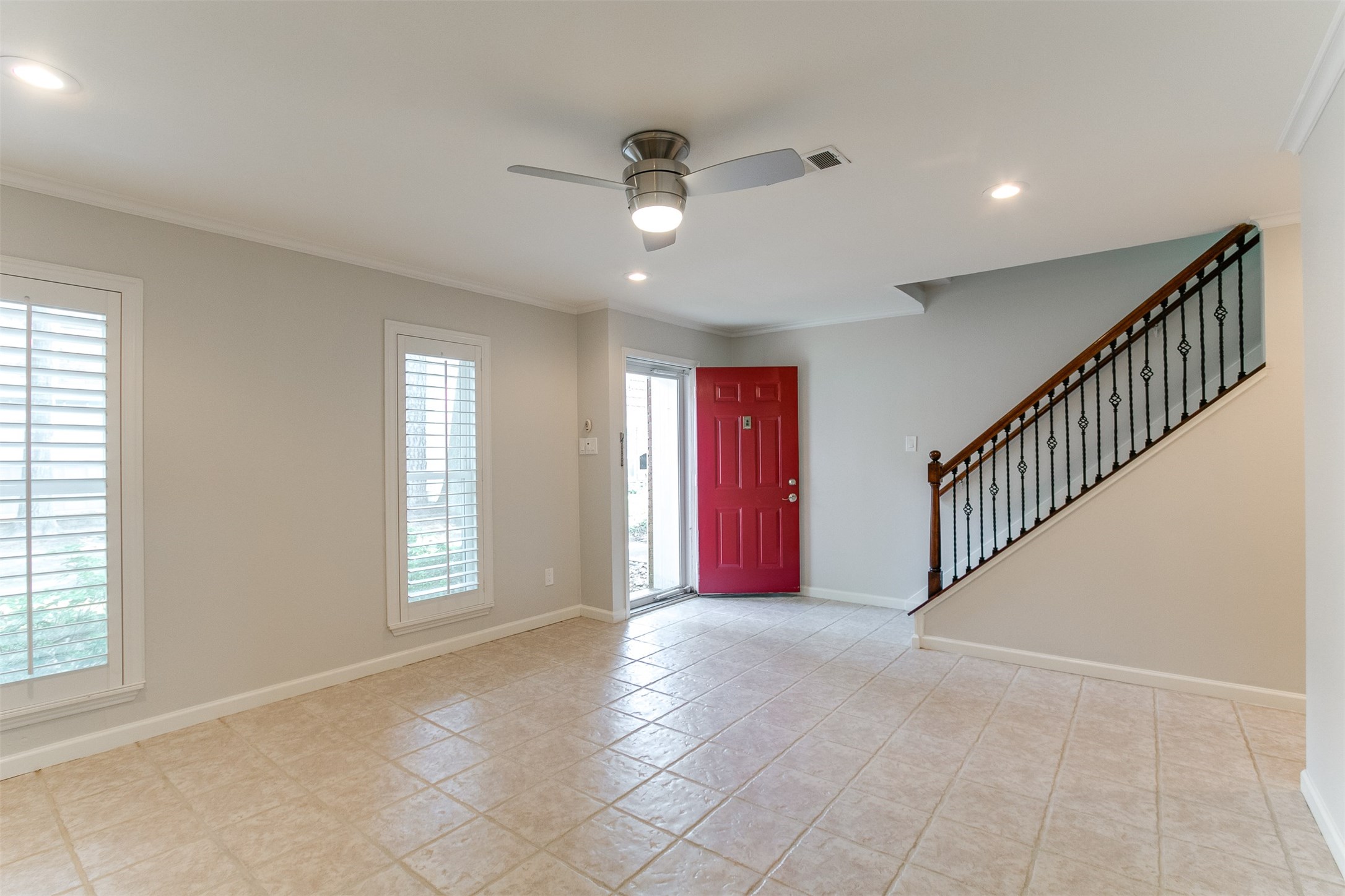 1407 Springrock Lane Houston, TX 77055 - Photo 3 of 25 Nothing says "Welcome" like a red door! It leads to the spacious Family Room with tile flooring, modern lighted ceiling fan, recessed lighting and plantation shutters.