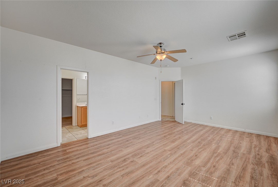 4437 Dover Straight Street, Unit 208 Las Vegas, NV 89115 - Photo 16 of 33 Unfurnished bedroom with light wood-style floors, ceiling fan, and ensuite bath