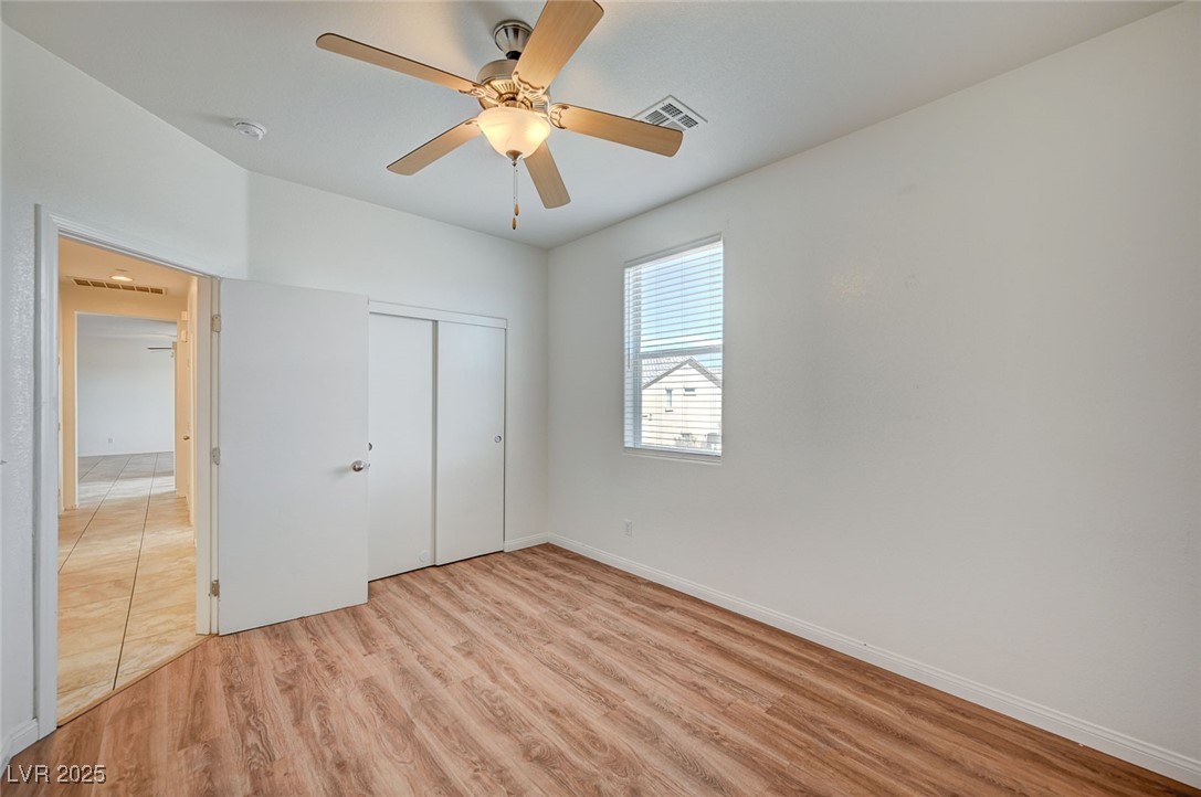 4437 Dover Straight Street, Unit 208 Las Vegas, NV 89115 - Photo 22 of 33 Unfurnished bedroom with light wood finished floors, ceiling fan, and a closet