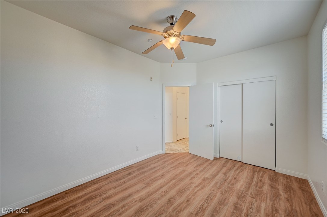 4437 Dover Straight Street, Unit 208 Las Vegas, NV 89115 - Photo 23 of 33 Unfurnished bedroom featuring light wood-style flooring, a closet, and ceiling fan