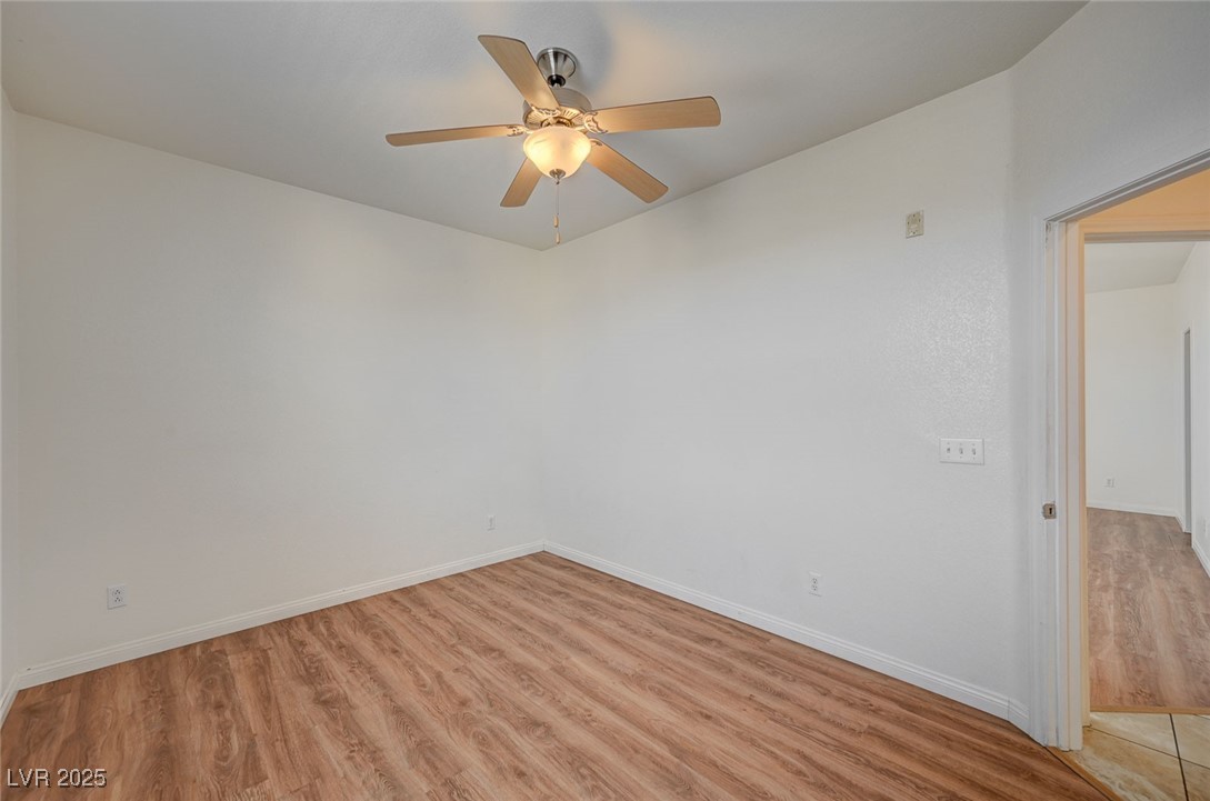 4437 Dover Straight Street, Unit 208 Las Vegas, NV 89115 - Photo 24 of 33 Empty room with light wood-style floors and a ceiling fan