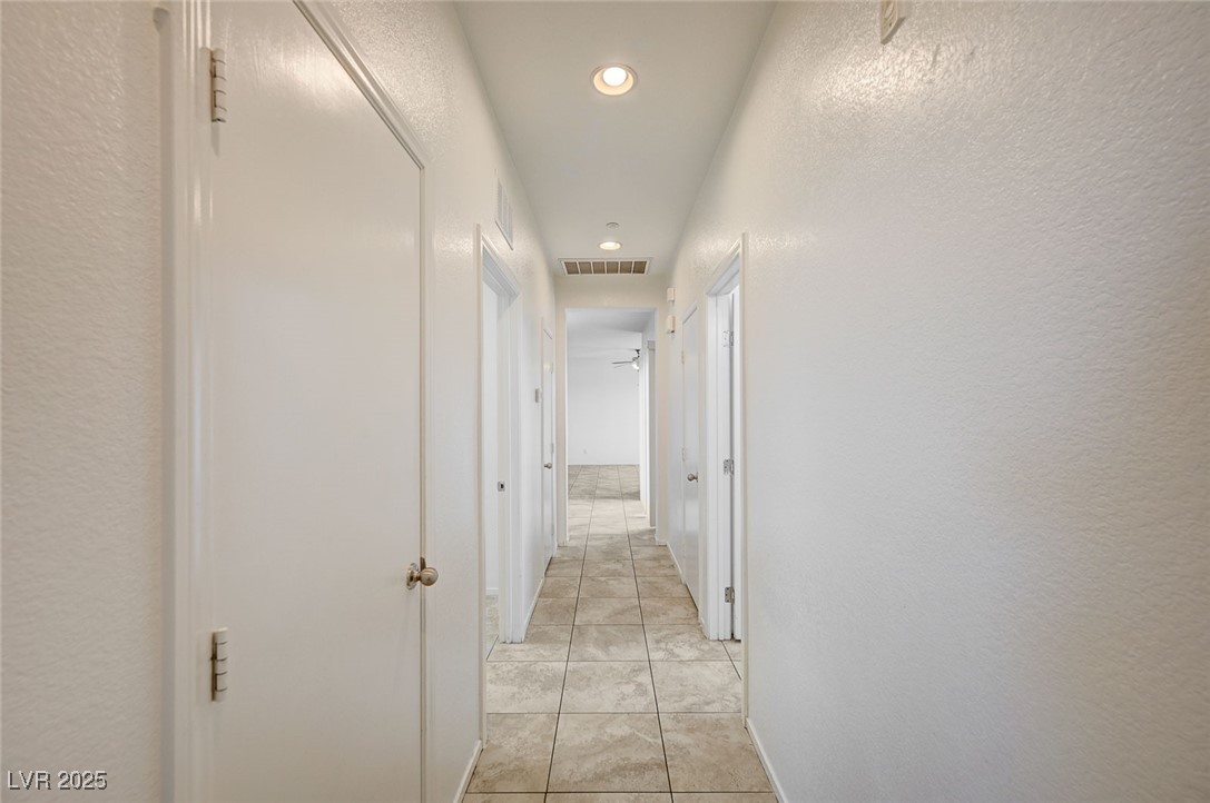 4437 Dover Straight Street, Unit 208 Las Vegas, NV 89115 - Photo 25 of 33 Hallway with a textured wall, light tile patterned floors, and recessed lighting