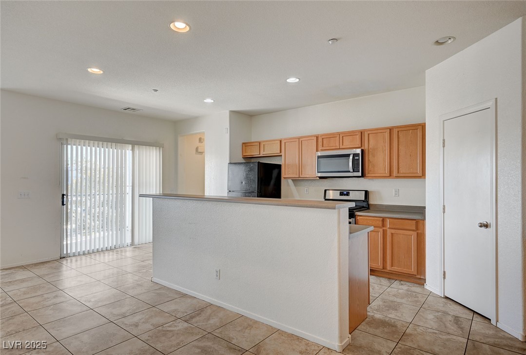 4437 Dover Straight Street, Unit 208 Las Vegas, NV 89115 - Photo 7 of 33 Kitchen featuring appliances with stainless steel finishes, recessed lighting, a kitchen island, light countertops, and light tile patterned floors