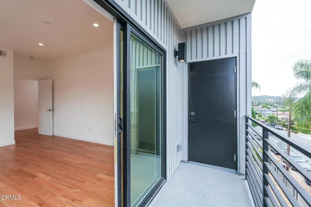 a view of hallway with a large window and wooden floor
